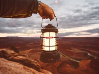 man holding a barebones camping lantern and other tips for choosing a camping lantern