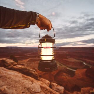 man holding a barebones camping lantern and other tips for choosing a camping lantern